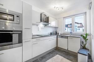 a white kitchen with a sink and a window at Fewo Nele in Gries