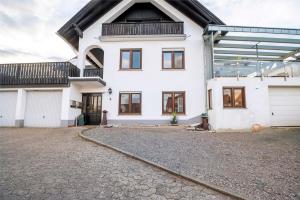 a white house with a driveway in front of it at Fewo Nele in Gries