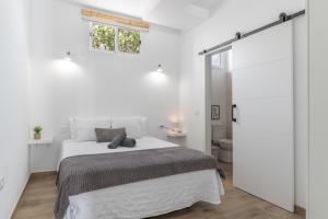 a white bedroom with a bed and a window at Rincón De Agustín in Mácher