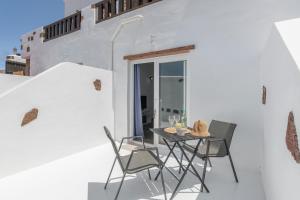 a patio with a table and chairs on a white wall at Rincón De Agustín in Mácher