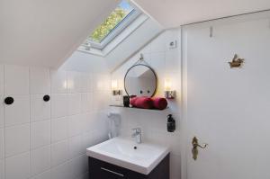 a bathroom with a sink and a mirror at Haus Schlossgarten in Hinte +88 photos