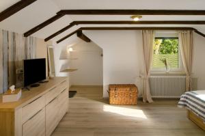 a bedroom with a tv on a dresser and a window at Haus Schlossgarten in Hinte