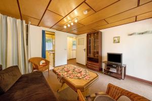 a living room with a couch and a tv at Bungalow 17 - Kimbucht in Reichendorf