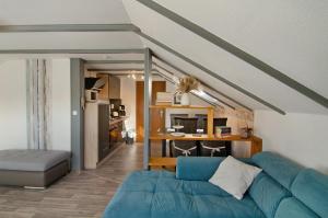 a living room with a blue couch and a kitchen at Haus Schlossgarten in Hinte