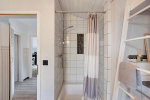 a shower in a bathroom with white tiles at Ferienwohnung Pöttner in Germete