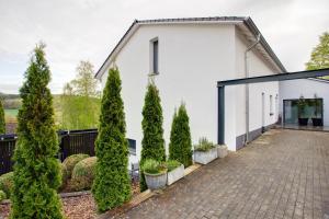 a white house with trees and a driveway at Ferienwohnung Pöttner in Germete