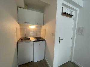 a small kitchen with white cabinets and a sink at Hyper centre, rue piétonne, calme et lumineux in Dijon