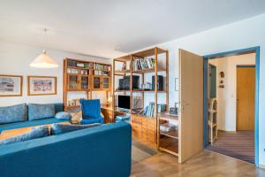 a living room with a blue couch and a tv at Terrassenpark Apartment 160 in Schonach