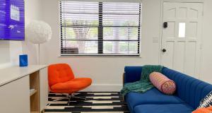 a living room with a blue couch and an orange chair at After Hours - Wilton Drive and Jacuzzi in Fort Lauderdale +15 photos
