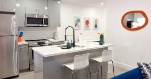 a kitchen with a sink and a counter with chairs at After Hours - Wilton Drive and Jacuzzi in Fort Lauderdale
