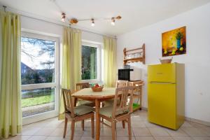 a kitchen with a table and a yellow refrigerator at Ferienwohnung Schoeneberg in Vogt