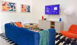 a living room with a blue couch and an orange chair at After Hours - Wilton Drive and Jacuzzi in Fort Lauderdale