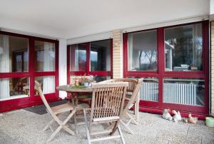 a patio with a table and chairs and windows at Ferienwohnung Schoeneberg in Vogt +18 photos