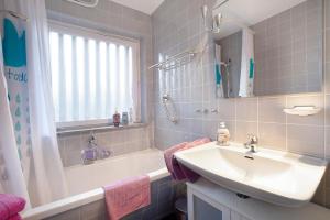 a bathroom with a sink and a shower and a tub and a sink at Ferienwohnung Schoeneberg in Vogt
