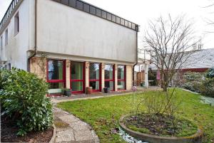 a building with red windows and a yard at Ferienwohnung Schoeneberg in Vogt