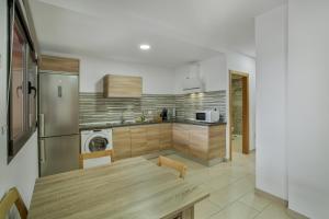 a kitchen with a wooden table in a kitchen at Edificio Bentejui 1 in Las Palmas de Gran Canaria +14 photos