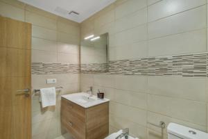 a bathroom with a sink and a mirror at Edificio Bentejui 1 in Las Palmas de Gran Canaria
