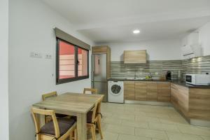 a kitchen with a wooden table and a refrigerator at Edificio Bentejui 1 in Las Palmas de Gran Canaria