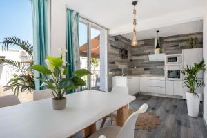 a kitchen with a white table and white chairs at Casa Mirajanda in Vejer de la Frontera