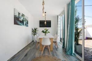 a dining room with a white table and chairs at Casa Mirajanda in Vejer de la Frontera