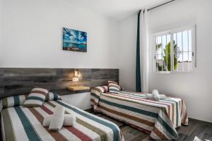 a room with two beds with striped blankets at Casa Mirajanda in Vejer de la Frontera +20 photos