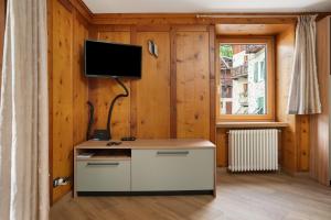 a room with a desk with a tv on the wall at Casa Picchio in Rabbi