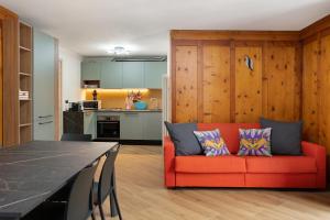 a living room with a red couch and a kitchen at Casa Picchio in Rabbi