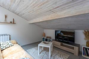 a living room with a couch and a flat screen tv at Maison Xara-heguia in Hasparren