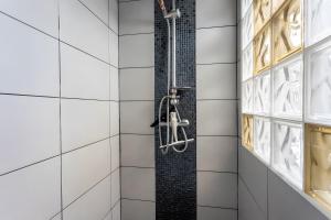 a shower in a bathroom with white tiles at Maison Xara-heguia in Hasparren +14 photos