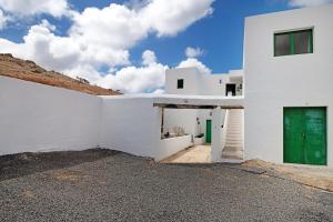 a white building with a green door on the side at San Roque 2 in Tinajo