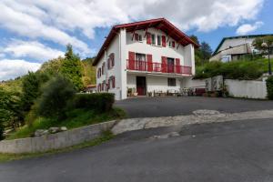 a large white house with a red roof at Maison Xara-heguia in Hasparren