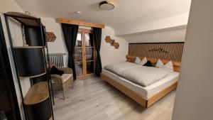 a small bedroom with a bed and a chair at Ferienwohnungen St Christoph in Mittenwald