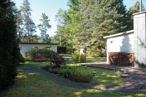 a garden with a white building and trees at Haus Waldidyll am Briesensee in Neu Zauche