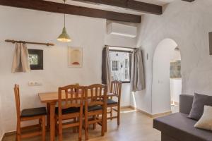 a dining room and living room with a table and chairs at Can Vital 1 in Illes Balears