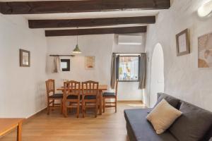 a dining room and living room with a table and chairs at Can Vital 1 in Illes Balears