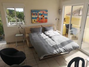 a bedroom with a bed and a couch and windows at Roca Penthouse in Estepona +22 photos