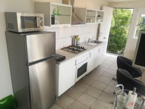 a kitchen with a stainless steel refrigerator and a microwave at Roca Penthouse in Estepona