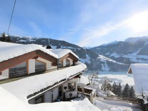 a house covered in snow with a view of a mountain at Apartment Melissa in Zellberg