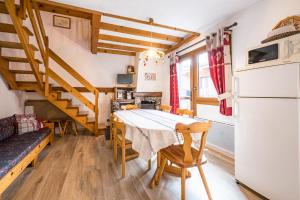 a kitchen and dining room with a table and a refrigerator at L'esterelle in La Plagne Tarentaise
