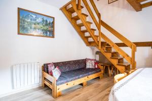 a living room with a couch and a staircase at L'esterelle in La Plagne Tarentaise