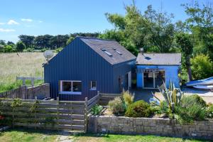 a blue house with a fence in front of it at Petit Duplex Proche Mer in Plouhinec