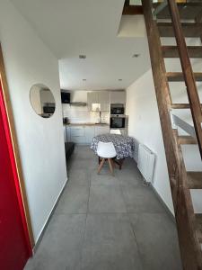 a small room with a table and a kitchen at Petit Duplex Proche Mer in Plouhinec +18 photos