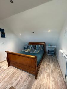 a bedroom with a wooden bed in a room at Petit Duplex Proche Mer in Plouhinec