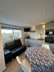a bedroom with a bed and a couch in a kitchen at Petit Duplex Proche Mer in Plouhinec