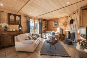 a living room with a white couch and a fireplace at Chalet Velajule in Manigod