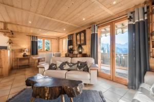 a living room with a couch and a table at Chalet Velajule in Manigod