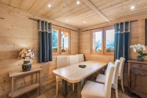 a dining room with a wooden table and chairs at Chalet Velajule in Manigod