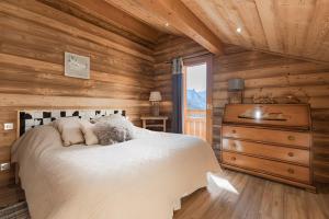 a bedroom with a bed in a wooden cabin at Chalet Velajule in Manigod