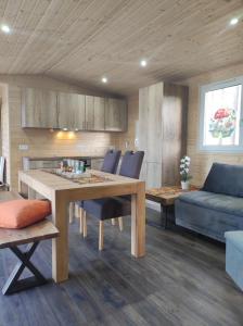 a kitchen and living room with a table and a couch at Unser Großer - Tiny House in Mayrhof