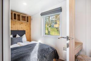 a bedroom with a bed and a window at Side-by-Side Tiny Houses in Untergriesbach
